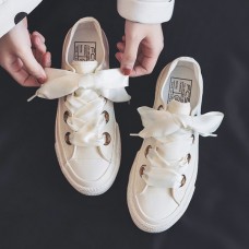 Small white shoes with ribbon and bow